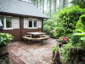 a patio with a picnic table and a house at Luxurious Chalet in Oud Turnhout with Large Garden in Oud-Turnhout