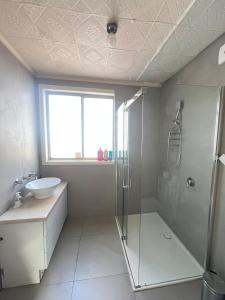 a bathroom with a shower and a sink at Seaside Sanctuary in Aspendale