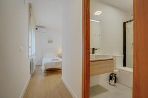 a bathroom with a sink and a mirror and a bed at Molí de Mar - Smart Hotel in Lloret de Mar +80 photos