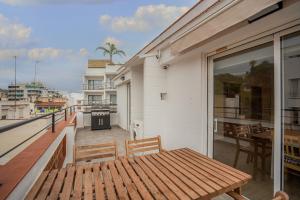 a wooden bench on the balcony of a building at Molí de Mar - Smart Hotel in Lloret de Mar