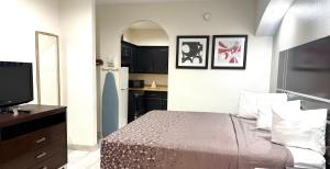 a small bedroom with a bed and a kitchen at Crystal Inn - Garth Rd in Baytown
