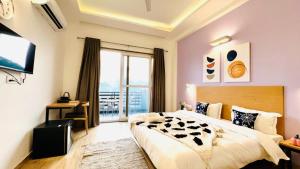 a bedroom with a large bed and a large window at ZEN Medicity - Boutique Hotel Gurgaon in Gurgaon