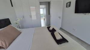 a bed with a napkin and a watch on it at Protaras Heights- Hana in Paralimni +7 photos