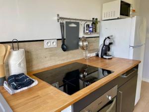 a kitchen with a wooden counter top with a refrigerator at EasyHome 26 in Vitré