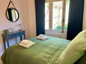 a bedroom with a green bed with towels on it at EasyHome 26 in Vitré