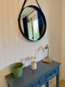 a mirror sitting on top of a blue dresser at EasyHome 26 in Vitré +6 photos