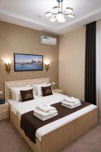 a bedroom with a large bed with towels on it at GRAND CARAVAN in Tashkent +32 photos