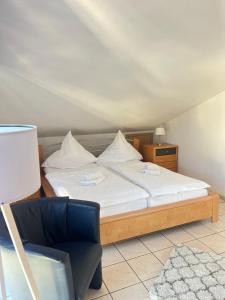 a bedroom with a bed and a blue chair at Weingut Sauer-Kettermann in Enkirch