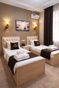 a hotel room with two beds in a room at GRAND CARAVAN in Tashkent