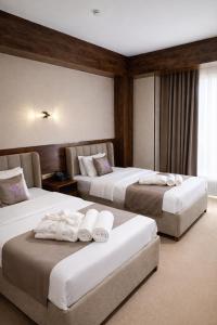 a hotel room with two beds with towels on them at GRAND CARAVAN in Tashkent