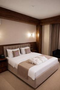 a bedroom with a large bed with towels on it at GRAND CARAVAN in Tashkent