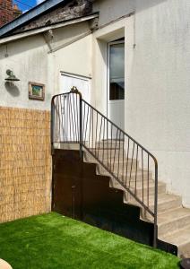 a staircase leading up to a house with green grass at AppartCosy 10 in Vitré
