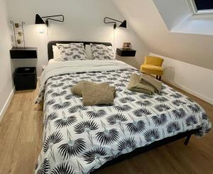 a bedroom with a bed with a black and white comforter at AppartCosy 10 in Vitré