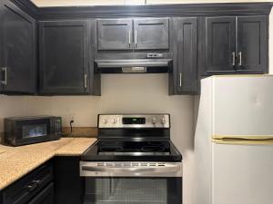 a kitchen with black cabinets and a stove top oven at Crystal Inn - Garth Rd in Baytown
