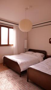 a bedroom with two beds and a chandelier at yua sugar home in Daegu
