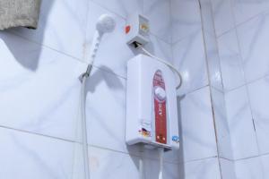 a white tiled bathroom with a red object on a wall at Anda De Boracay White Sand Resort in Anda +21 photos