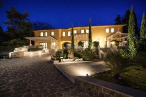 a house with a driveway in front of it at night at Country Lodge B&B in Siena