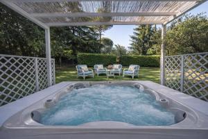 a hot tub in a backyard with a pergola at Country Lodge B&B in Siena