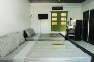 a living room with a couch and a tv at Tukad Guest House in Sampong