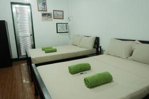 two beds in a room with green pillows on them at Tukad Guest House in Sampong +12 photos