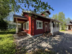a small red brick house with a porch at Lumilyhty A in Äkäslompolo