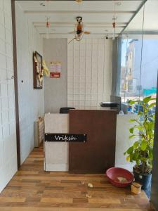 a restaurant with a sign on a counter in a room at Hotel Vriksh Stay in Godarpura