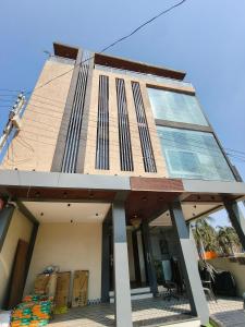 a building with a lot of windows on it at Hotel Vriksh Stay in Godarpura