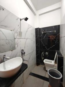 a bathroom with a sink and a toilet at Hotel Vriksh Stay in Godarpura