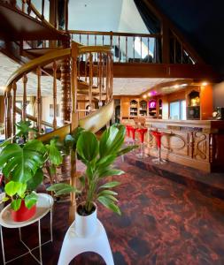 a lobby with tables and plants and a staircase at AppartCosy 15 in Vitré