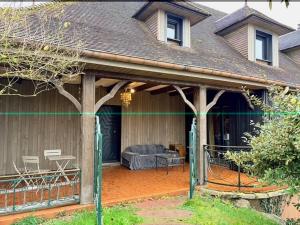 a screened in porch of a house with a couch at AppartCosy 15 in Vitré