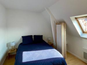 a bedroom with a bed with blue sheets and a window at EasyHome 23 in Vitré