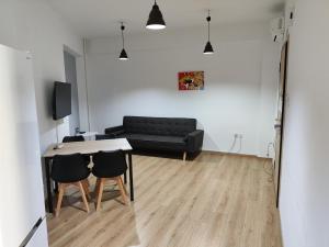 a living room with a couch and a table and chairs at Ulysses Apartments Ermou in Athens