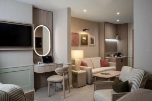 a living room with a couch and chairs and a television at North Lakes Hotel and Spa in Penrith
