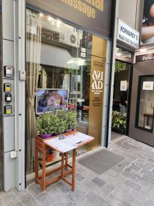 a bench in front of a store with a potted plant at Ulysses Apartments Ermou in Athens