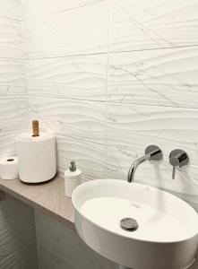 a white bathroom with a sink and a counter at Pokoje Chojnice in Chojnice