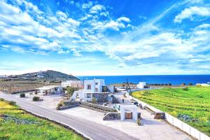 a building on the side of a road next to the ocean at La Ponta Villas & Suites in Akrotiri