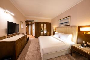 a hotel room with a bed and a flat screen tv at Luxe Avenue Hotel in Dubai +51 photos