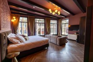 a bedroom with a bed and a couch and windows at Bakery Boutique Hotel in Leeuwarden