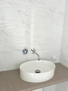 a white sink with a faucet in a bathroom at Pokoje Chojnice in Chojnice