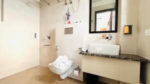 a bathroom with a toilet and a sink and a mirror at ZEN Medicity - Boutique Hotel Gurgaon in Gurgaon +32 photos