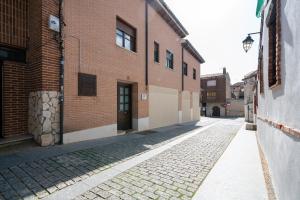 an empty alley with a brick building and a door at Apartamentos GO - Simancas in Simancas