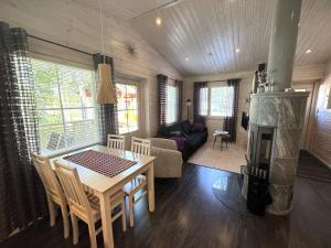 a living room with a table and a fireplace at Lumilyhty A in Äkäslompolo