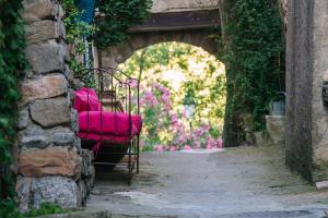a chair with a pink cushion sitting in an archway at Le Roc sur l'Orbieu in Saint-Pierre-des-Champs