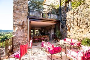 an outdoor patio with pink chairs and a table at Le Roc sur l'Orbieu in Saint-Pierre-des-Champs