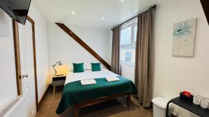 a bedroom with a bed with green sheets and a window at Town Lodge in Newquay +42 photos