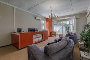 a living room with a couch and a reception desk at Ulifalodge whitehouse in Hillcrest