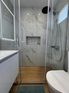 a white bathroom with a shower and a toilet at Yiallos Village Apt. A101 in Meneou +25 photos