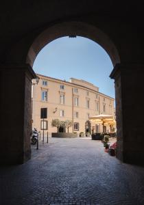 an archway leading to a large building with a building at Emme Palace Hotel & Spa in Orvieto