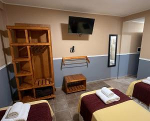 a room with two beds and a flat screen tv at Apart Hotel Belgrano in Perico