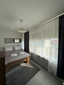 a bedroom with a bed and a large window at Apartman "WALKOW", SELF CHECK IN, FREE PARKING in Vukovar
